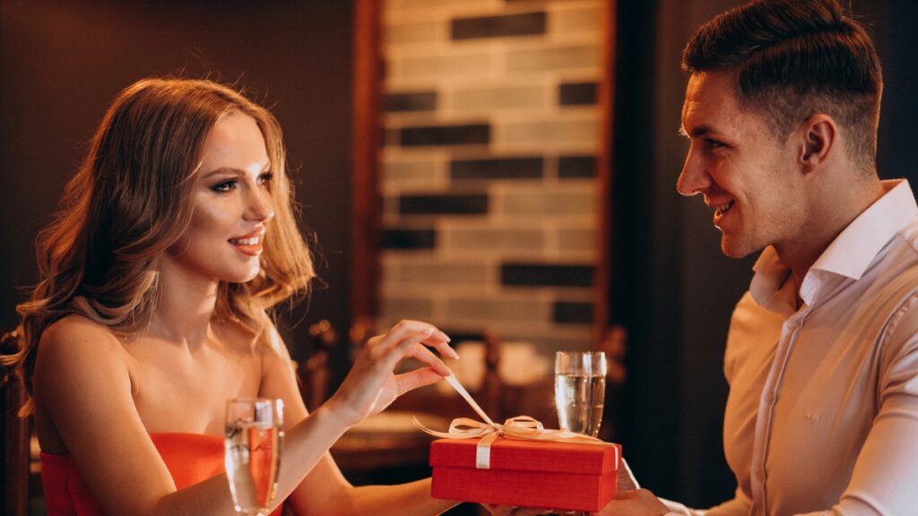 A man giving a gift for his girlfriend on their date.
